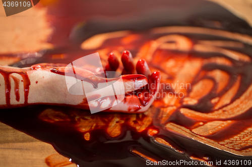 Image of dead woman hand in blood on floor at crime scene