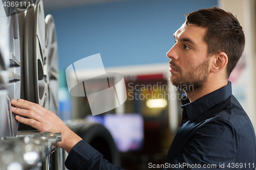 Image of male customer choosing wheel rims at car service