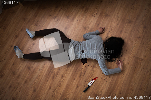 Image of dead woman body lying on floor at crime scene