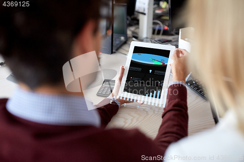 Image of business team with charts on tablet pc at office