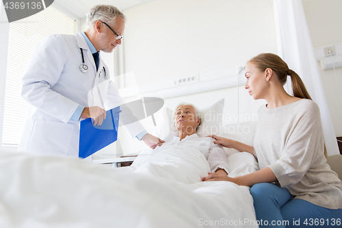 Image of senior woman and doctor with clipboard at hospital