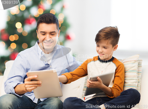 Image of happy father and son with tablet pc at christmas