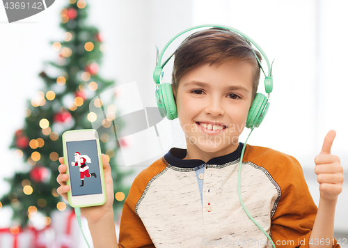 Image of boy with smartphone and headphones at christmas