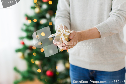 Image of close up of man with christmas gift at home