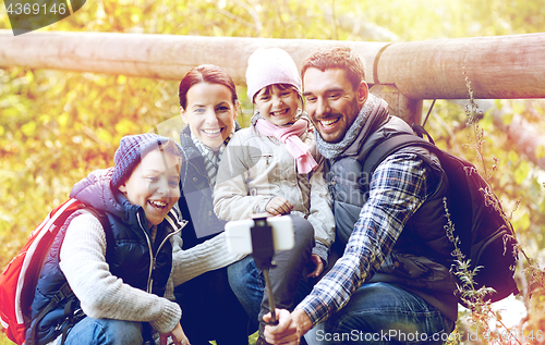 Image of family with backpacks taking selfie and hiking