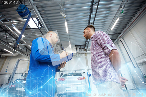 Image of auto mechanic with clipboard and man at car shop