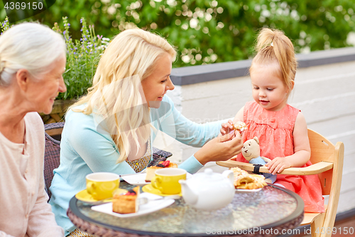 Image of mother, daughter and grandmother eating at cafe