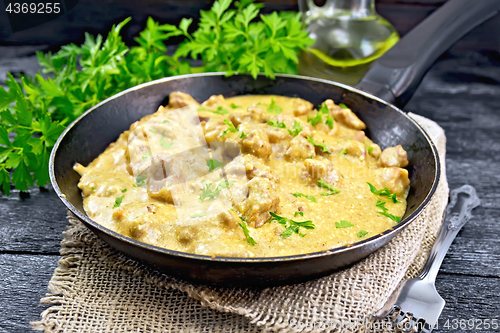 Image of Meat stewed with cream in pan on burlap