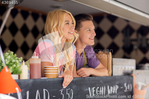 Image of happy young sellers at food truck