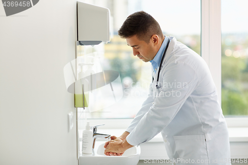 Image of doctor washing hands at medical clinic sink