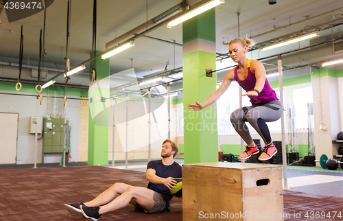 Image of woman and man with medicine ball exercising in gym