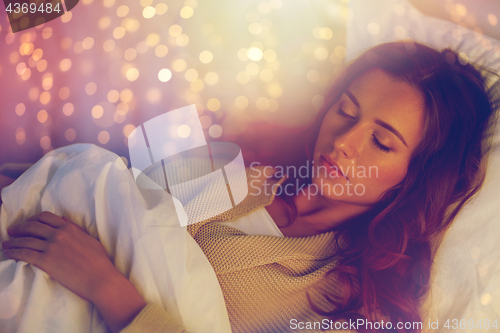 Image of young woman sleeping in bed at home