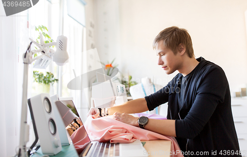 Image of fashion designer with sewing machine working