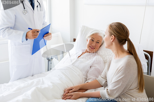 Image of senior woman and doctor with clipboard at hospital