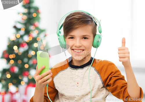 Image of boy with smartphone and headphones at christmas