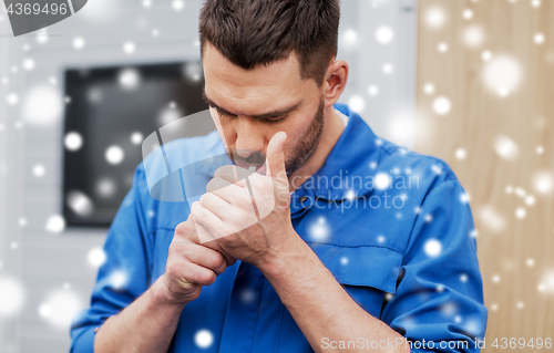 Image of auto mechanic lighting up or smoking cigarette