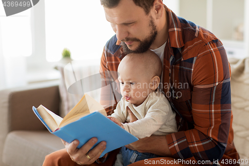 Image of happy father and little baby boy with book at home