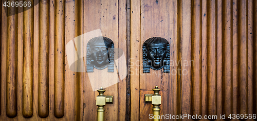 Image of Sphinx heads entrance on wooden door