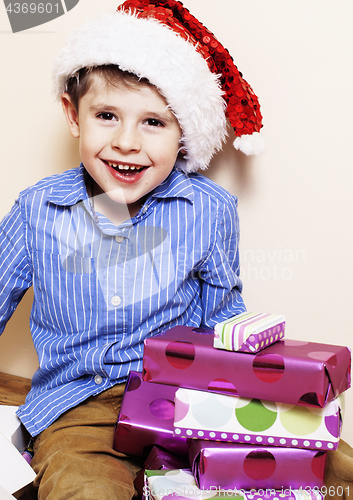 Image of little cute boy with Christmas gifts at home. close up emotional