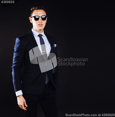 Image of young pretty business man standing on black background, modern h