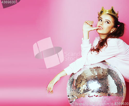 Image of young cute disco girl on pink background with disco ball and cro