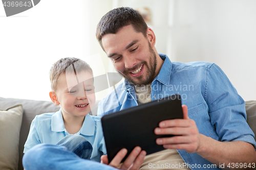 Image of father and son with tablet pc playing at home