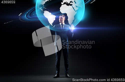 Image of businessman with earth hologram over black