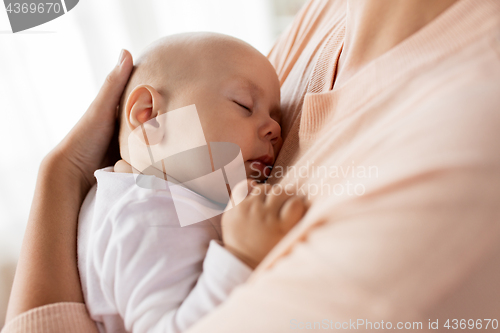 Image of close up of mother holding sleeping baby