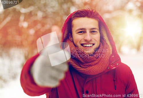 Image of happy man in winter jacket showing thumbs up