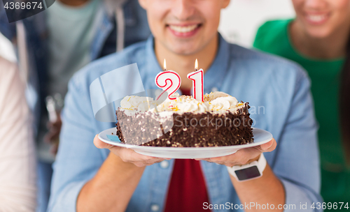 Image of man with cake and friends at birthday party