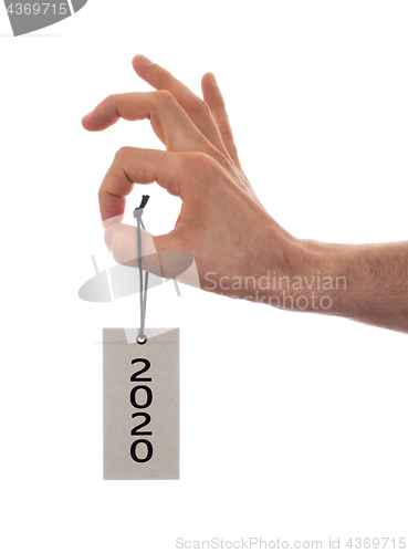 Image of Hand holding a tag - New year - 2020