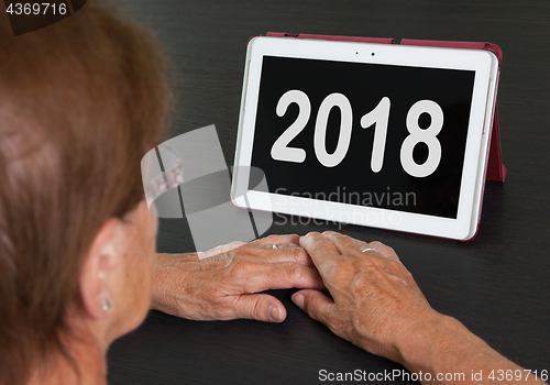 Image of Senior lady relaxing and her tablet - 2018