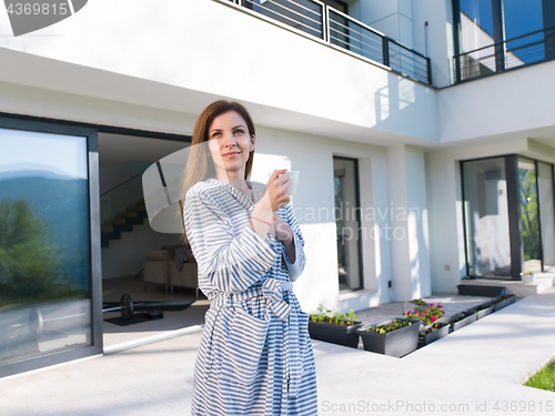 Image of woman in a bathrobe enjoying morning coffee
