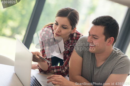 Image of happy young couple buying online