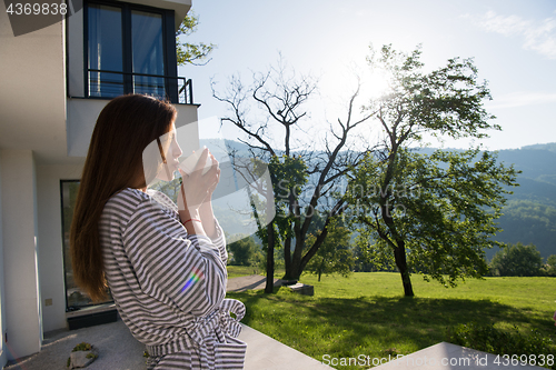 Image of woman in a bathrobe enjoying morning coffee