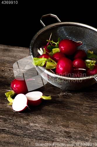 Image of Several red radishes in a sieve