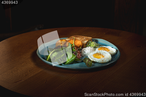 Image of Scrambled eggs on meat with fried potatoes and toast
