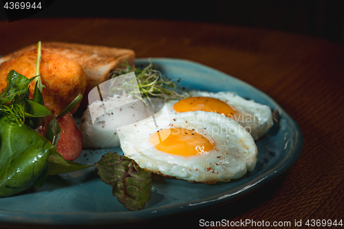 Image of Scrambled eggs on meat with fried potatoes and toast