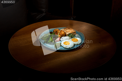 Image of Scrambled eggs on meat with fried potatoes and toast