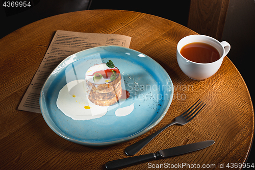 Image of plate with tasty pancakes on wooden table