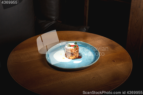 Image of plate with tasty pancakes on wooden table