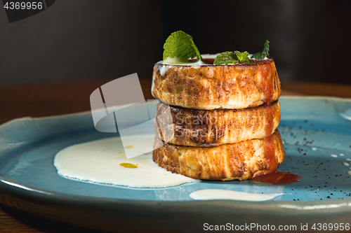 Image of plate with tasty pancakes on wooden table