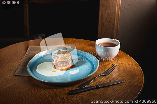 Image of plate with tasty pancakes on wooden table