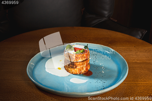 Image of plate with tasty pancakes on wooden table