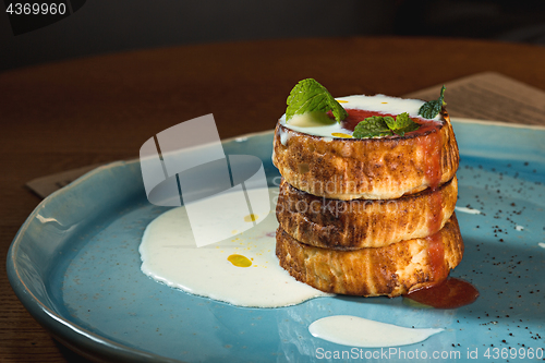 Image of plate with tasty pancakes on wooden table