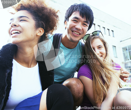 Image of cute group of teenages at the building of university with books huggings, back to school