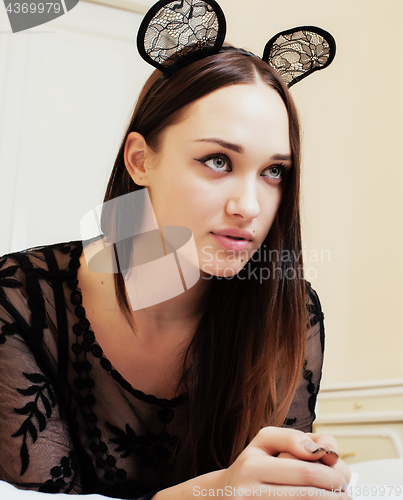 Image of young pretty brunette woman wearing sexy lace mouse ears, laying waiting dreaming in bed close up