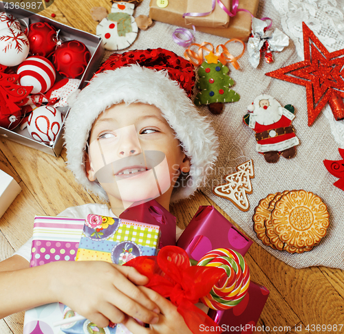 Image of little cute boy with Christmas gifts at home. close up emotional happy smiling in mess with toys, lifestyle holiday people concept