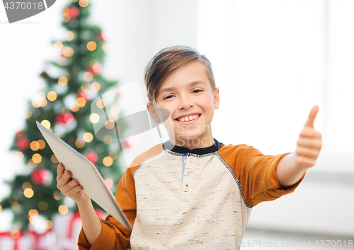 Image of boy with tablet pc showing thumbs up at christmas