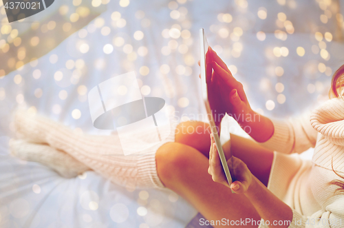 Image of young woman with tablet pc in bed at home